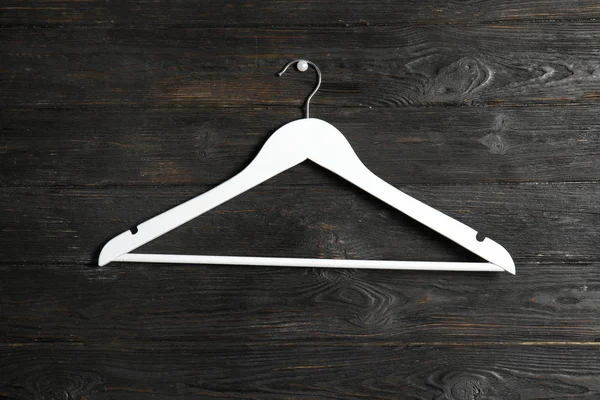 Lege kleding hanger op houten muur. Kledingkast accessoire — Stockfoto