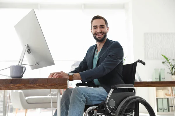 Portret młodego mężczyzny na wózku inwalidzkim w miejscu pracy — Zdjęcie stockowe
