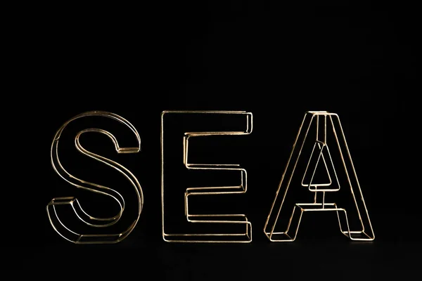 Palabra SEA de letras decorativas doradas sobre fondo negro — Foto de Stock