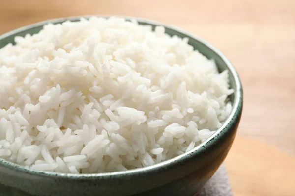 Cuenco de sabroso arroz blanco cocido en la mesa, primer plano —  Fotos de Stock