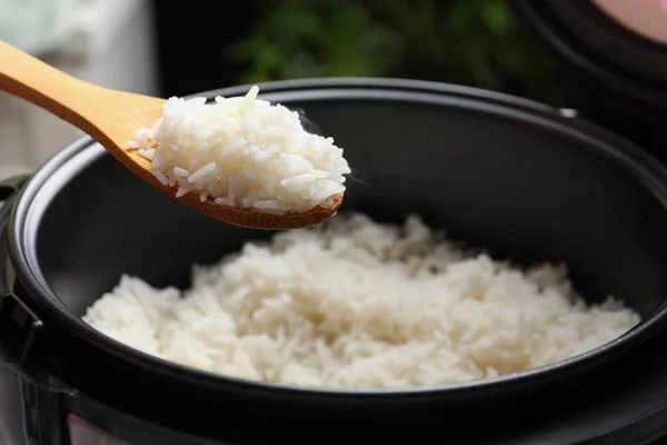 Sendok dengan nasi panas lezat di atas kompor, closeup — Stok Foto