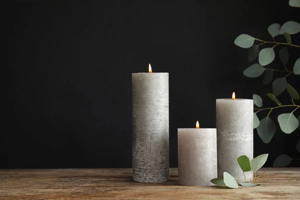 Composición con velas encendidas sobre la mesa sobre fondo negro. Espacio para texto —  Fotos de Stock