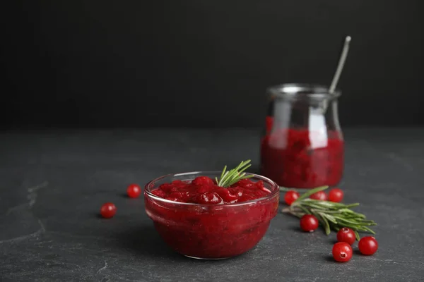 Bowl of cranberry sauce with rosemary on grey table — Stock Photo, Image