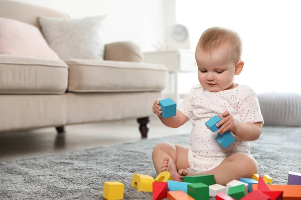 Niedliches kleines Mädchen, das mit Bausteinen im Raum spielt. Raum für Text — Stockfoto