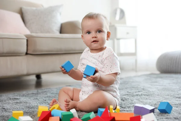 Linda niña jugando con bloques de construcción en la habitación — Foto de Stock