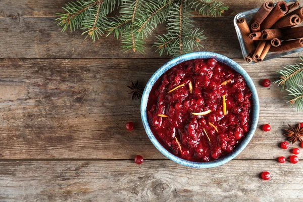 Flat lay composition with cranberry sauce in bowl on wooden background. Space for text — Stock Photo, Image