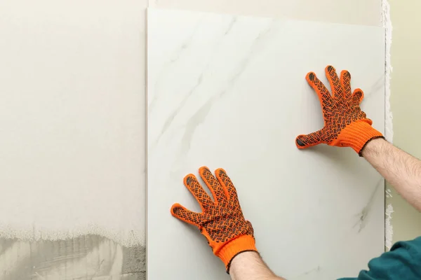 Homem instalando telha cerâmica na parede, espaço para texto. Obras de construção e renovação — Fotografia de Stock