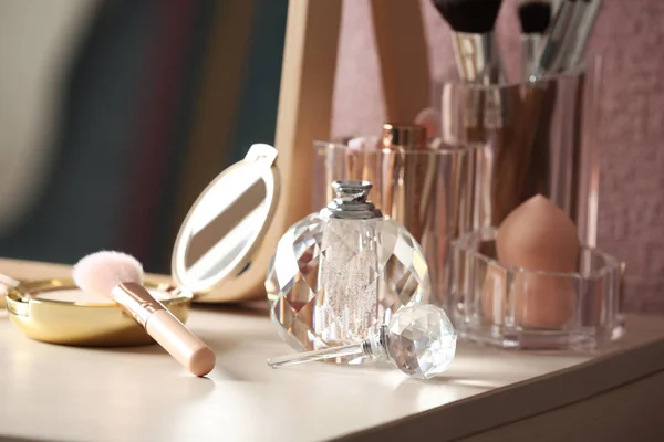 Kapesní prášek se štětcem a parfémem na toaletním stolku — Stock fotografie