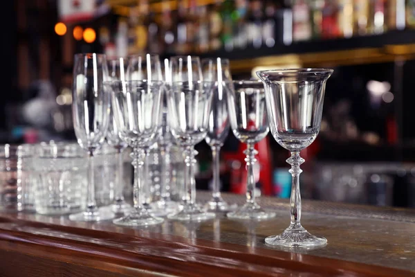 Diferentes vidros limpos vazios no balcão no bar — Fotografia de Stock
