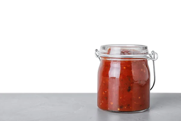 Tarro de vidrio de salsa de chile picante sobre la mesa sobre fondo blanco. Espacio para texto —  Fotos de Stock