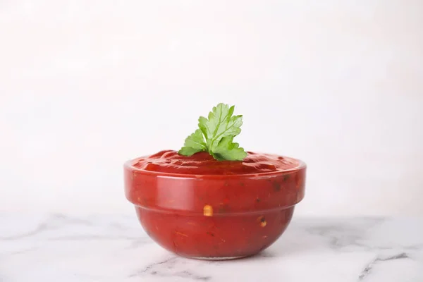 Cuenco de salsa de chile picante con perejil sobre la mesa sobre fondo blanco — Foto de Stock