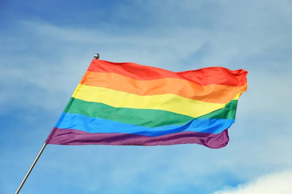 Bright rainbow gay flag revoloteando contra el cielo azul. Comunidad LGBT — Foto de Stock