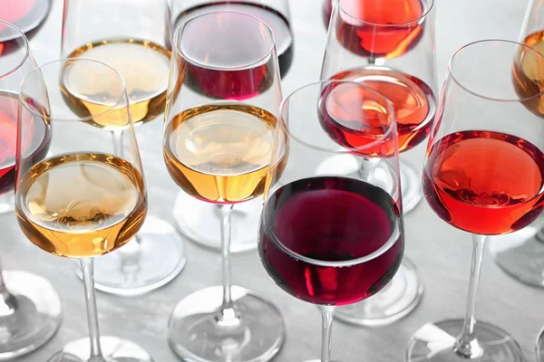 軽いテーブルの上に異なるワインを持つグラスのグループ — ストック写真