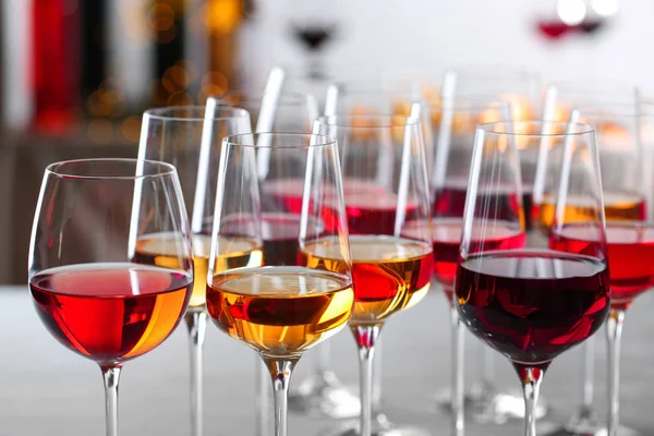 Glasses with different wines on blurred background, closeup — Stock Photo, Image