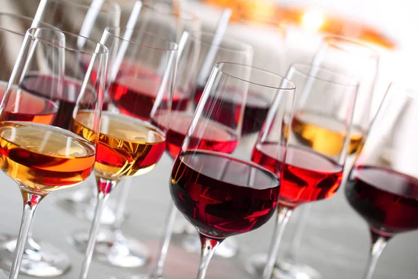 Glasses with different wines on blurred background, closeup — Stock Photo, Image