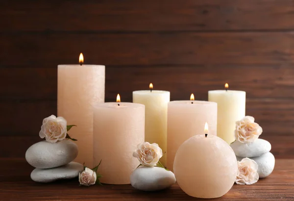 Composición de velas encendidas, piedras de spa y flores en la mesa. Espacio para texto — Foto de Stock