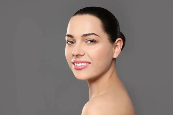 Porträtt av ung kvinna med vackert ansikte och naturlig makeup på färg bakgrund — Stockfoto