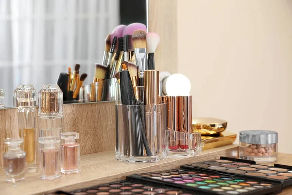 Conjunto de produtos de maquiagem de luxo, acessórios e perfumes na mesa de vestir no quarto. Espaço para texto — Fotografia de Stock