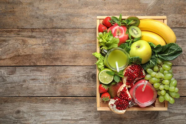 Holzkiste mit Säften in Einmachgläsern und frischem Obst auf Holzgrund, Draufsicht. Raum für Text — Stockfoto