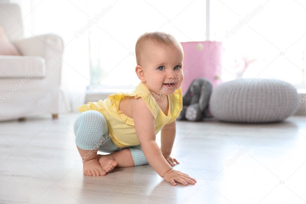 Cute baby girl on floor in room