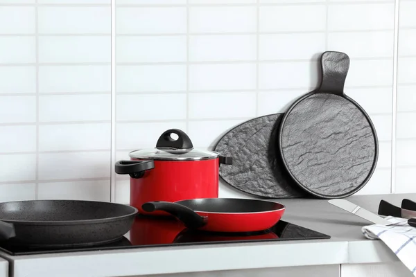 Different clean cookware on stove in kitchen. Space for text — Stock Photo, Image