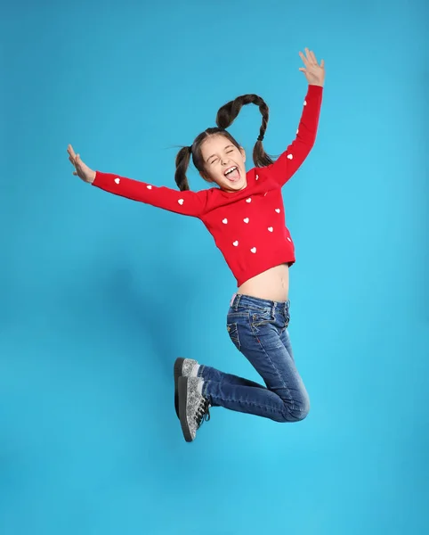 Renkli arka planda zıplayan küçük kızın portresi — Stok fotoğraf