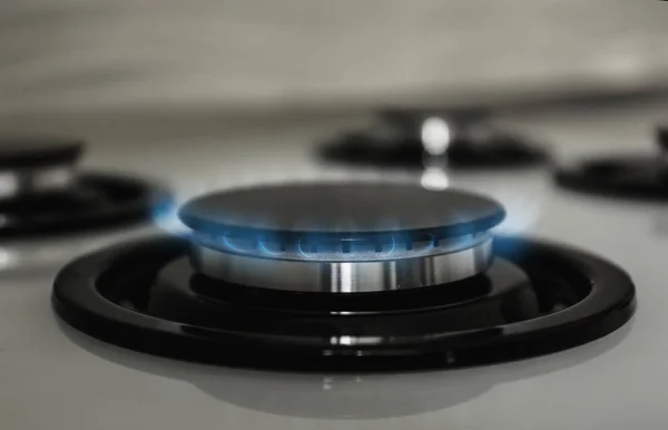 Gas burner with blue flame on modern stove, closeup — Stock Photo, Image