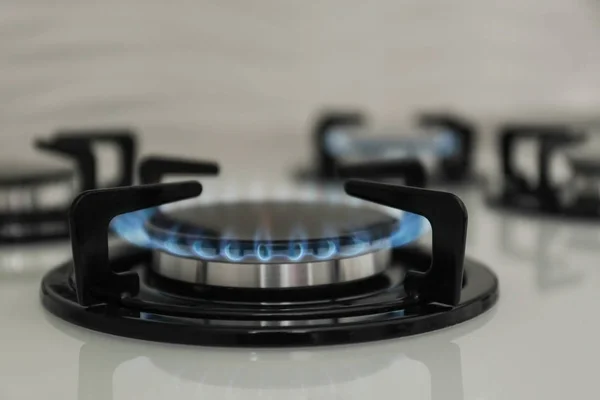 Gas burner with blue flame on modern stove, closeup — Stock Photo, Image