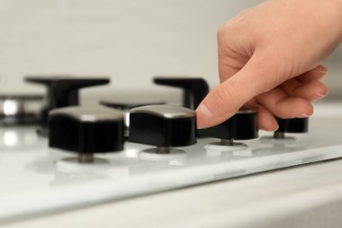 Gaz ocağı panelinde yemek pişirme modunu düzenleyen kadın, yakın çekim