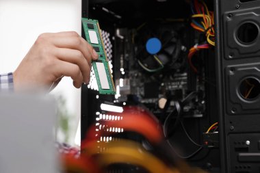 Erkek teknisyen, Ram çipini sistem ünitesine koyuyor, yakın çekim. Bilgisayar onarımı
