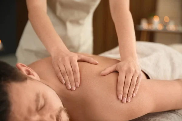 Hombre guapo recibiendo masaje de espalda en el salón de spa, primer plano — Foto de Stock