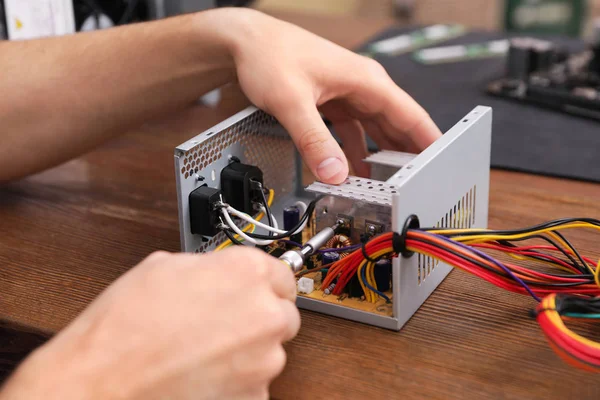 Maschio tecnico riparatore alimentatore a tavola, primo piano — Foto Stock