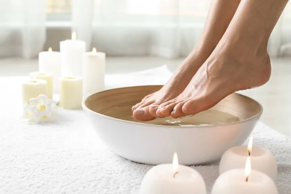 Woman soaking her feet in dish indoors, closeup with space for text. Spa treatment — 스톡 사진