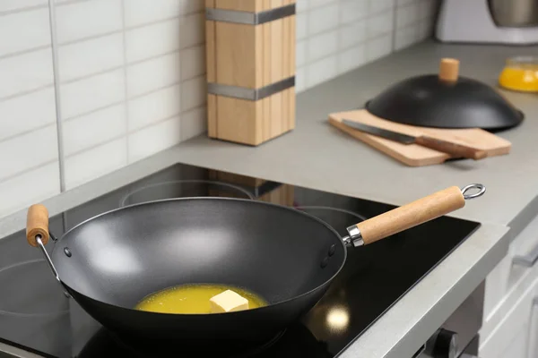 Сковородка с растопленным маслом на плите на кухне — стоковое фото
