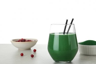 Beyaz arka plan karşı masada spirulina smoothie cam ile Kompozisyon. Metin için alan