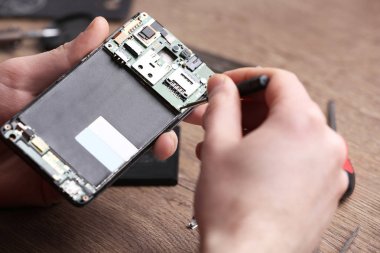 Teknisyen masada cep telefonu tamir, closeup. Cihaz onarım hizmeti