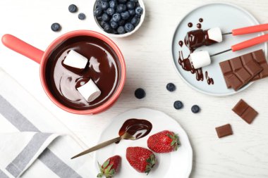 Ahşap masa üzerinde çilek ve marshmallow ile Çikolata fondü, düz yatıyordu