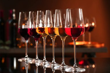 Bulanık arka plana karşı bar tezgahında farklı şaraplar içeren kadehler