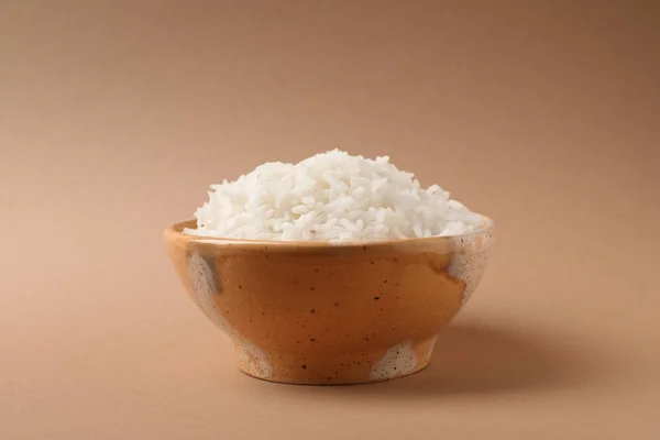 Cuenco de sabroso arroz cocido sobre fondo de color — Foto de Stock