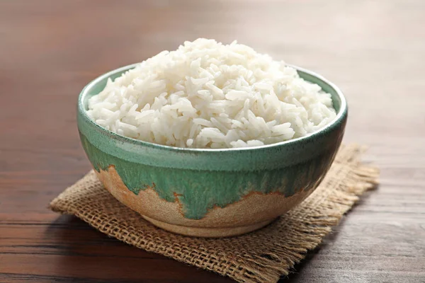 Tigela de arroz branco cozido saboroso em mesa de madeira, close-up — Fotografia de Stock
