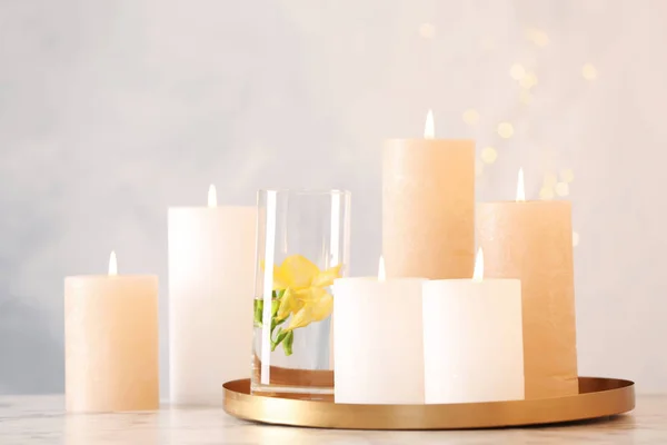 Composizione con candele accese sul tavolo sullo sfondo chiaro — Foto Stock