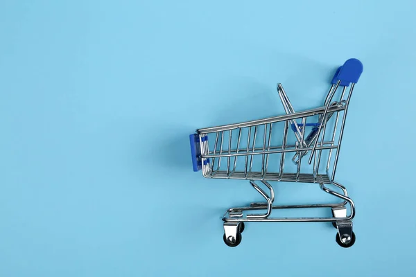 Töm shoppingvagn på färg bakgrund, uppifrån. Utrymme för text — Stockfoto
