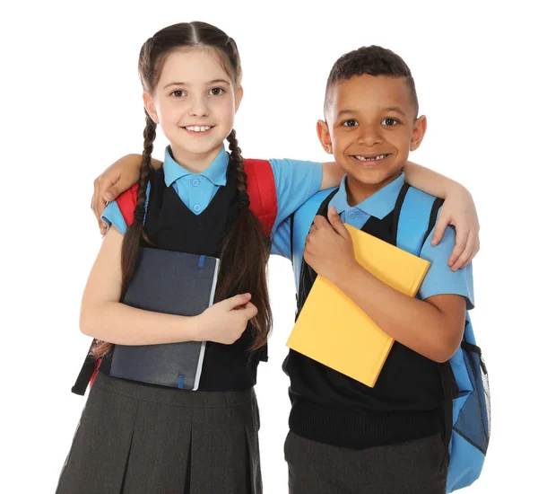 Πορτρέτο των χαριτωμένα παιδιά σε σχολική στολή με βιβλία σε λευκό φόντο — Φωτογραφία Αρχείου