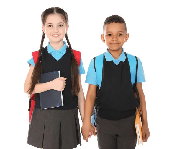 Portrait d'enfants mignons en uniforme scolaire avec des livres sur fond blanc — Photo