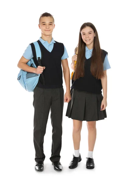 Retrato de comprimento total de adolescentes em uniforme escolar com mochilas em fundo branco — Fotografia de Stock