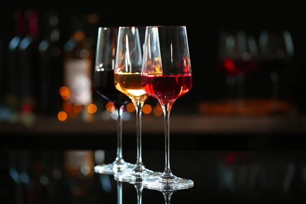 Fila de copas con diferentes vinos en barra contra fondo borroso — Foto de Stock