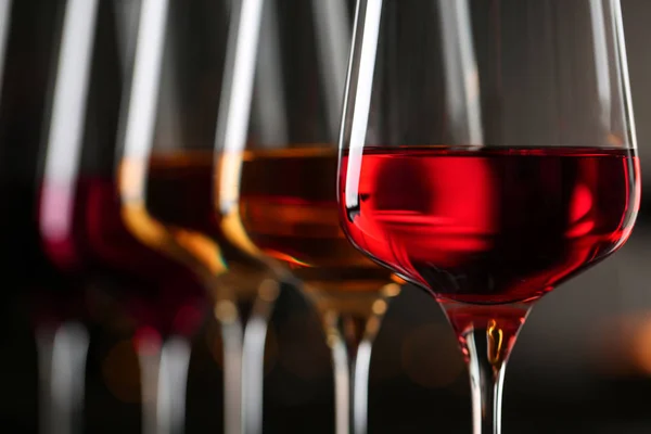 Rząd kieliszków z różnymi winami na niewyraźne tło, zbliżenie — Zdjęcie stockowe