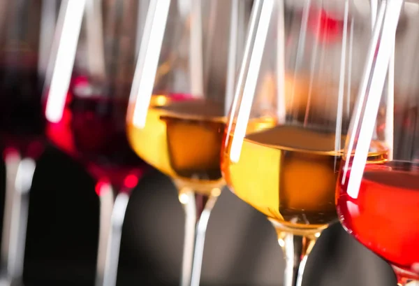 Fila de copos com diferentes vinhos em fundo desfocado, close-up — Fotografia de Stock