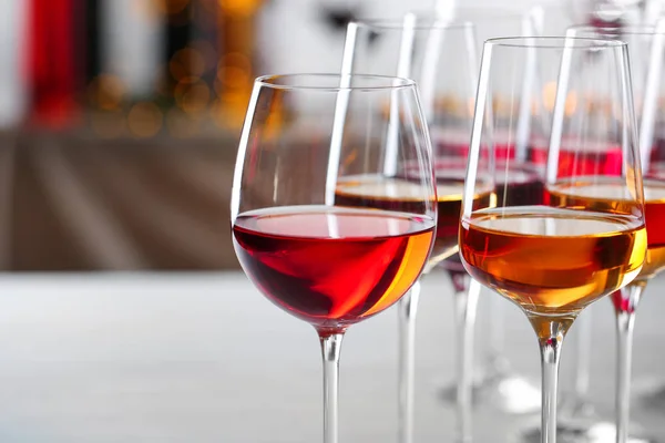 Glazen met verschillende wijnen op onscherpe achtergrond, close-up. Ruimte voor tekst — Stockfoto