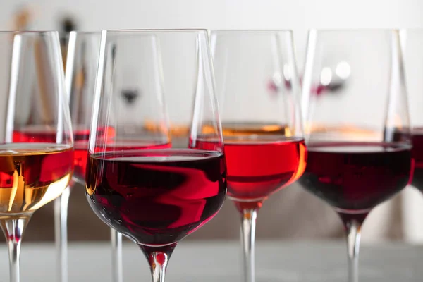 Glasses with different wines on blurred background, closeup — Stock Photo, Image